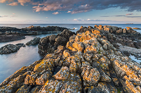 An atmospheric shot of a rocky beach used as an illustration in a camera guide.