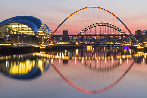 An image of the bridges over the River Tyne, and the Sage Gateshead, at sunset. 