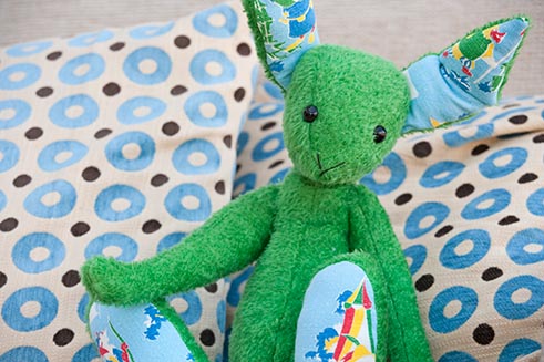A hand-crafted green rabbit by Emily Pitkethly, photographed for marketing purposes.