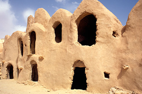 A travel photograph of mud-built grain stores in Tunisia, North Africa.